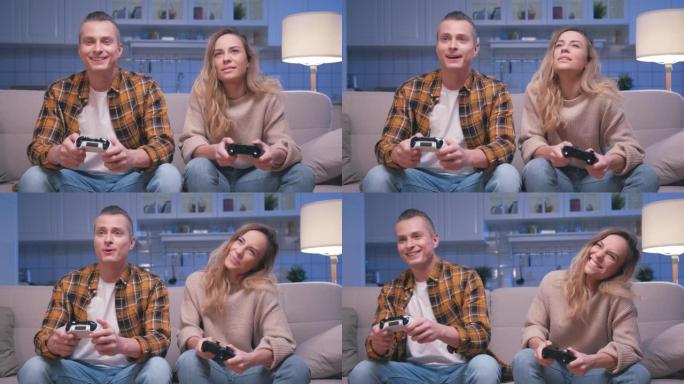 动作游戏玩家年轻的男人和女人坐在沙发上，在数字控制台上玩视频游戏。两名玩家在控制视频游戏操纵杆中玩游
