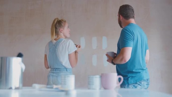 夫妇翻新厨房在家绘画测试仪在石膏墙上画彩色条-慢动作拍摄