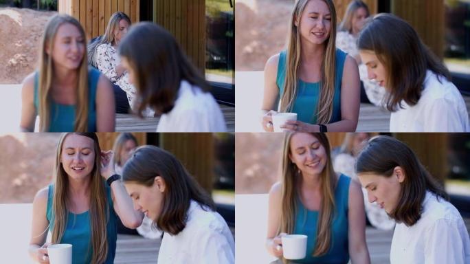 友谊和团结的概念。两个年轻快乐迷人的白人女性朋友在家庭露台上喝咖啡。