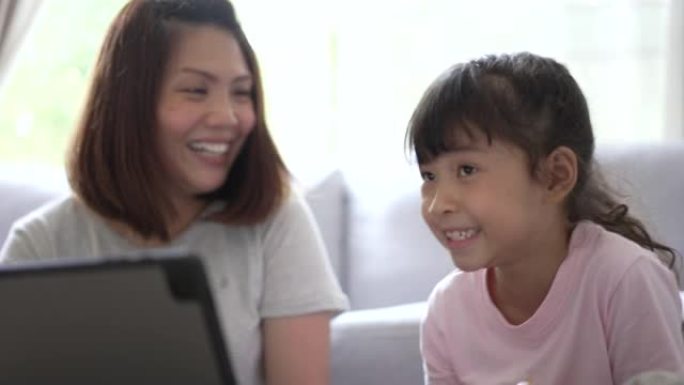 母女在数字平板电脑上观看和享受