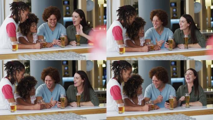 一群快乐的朋友在酒吧喝啤酒和使用智能手机