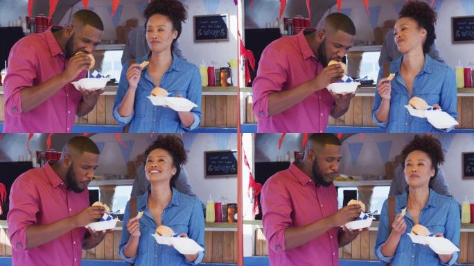 非裔美国夫妇在餐车上一起吃汉堡和薯条