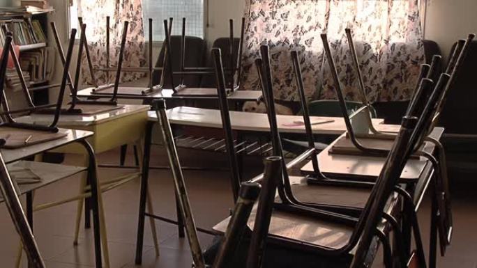 老式的学校椅子在空荡荡的教室里颠倒。