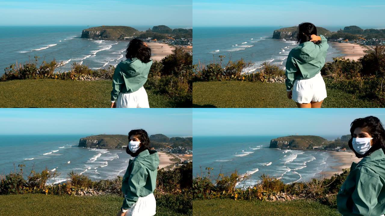 巴西南里奥格兰德州托雷斯海滩，戴着太阳镜和防护面罩的女人，欣赏海景