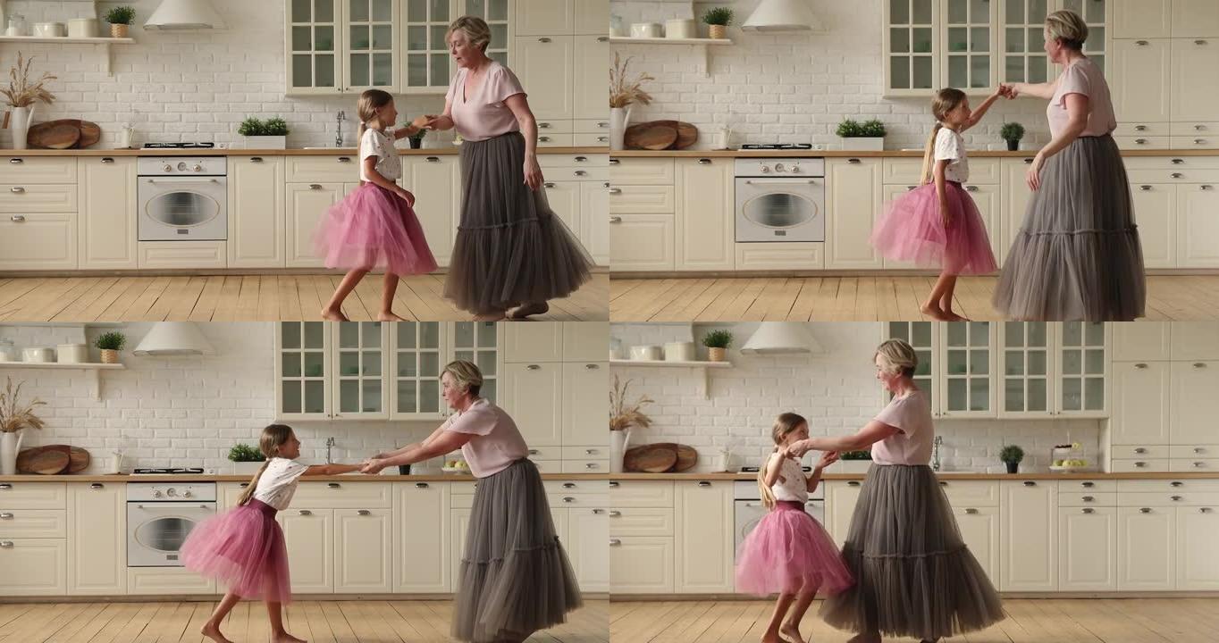 活跃的奶奶和小孙女在厨房跳舞华尔兹