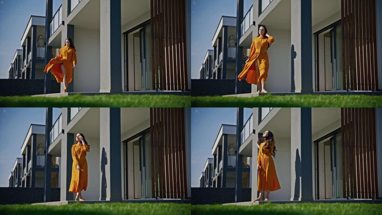 SLO MO年轻女子在现代房屋的步行甲板上享受阳光和清新的微风