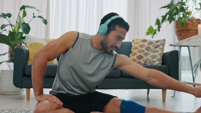 耳机、音乐和健身伸展男子在客厅公寓与动机或健康播客。地板上的年轻人进行锻炼训练或锻炼肌肉腿并听音频