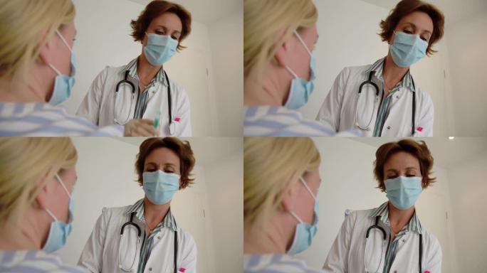 医生戴防护口罩给女人打疫苗