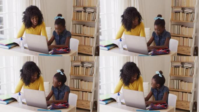 非裔美国母女微笑着看着对方并使用笔记本电脑