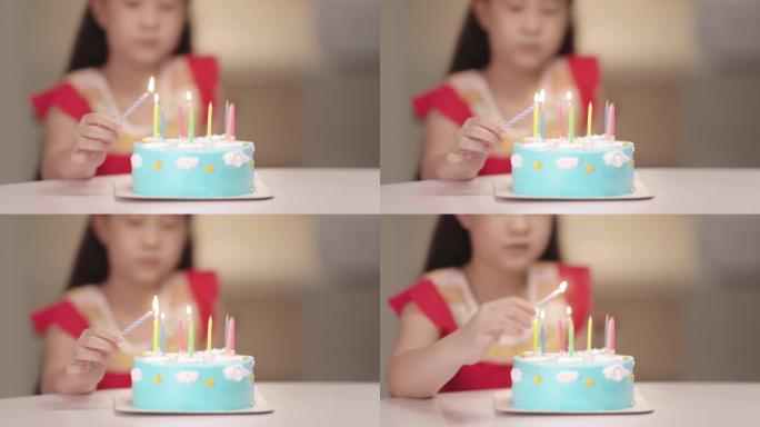 快乐的亚洲女孩在她的生日蛋糕上吹蜡烛