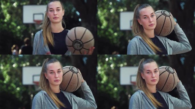 美丽的金发年轻女子在室外球场上看着相机时扔篮子球的肖像。女运动员无视刻板印象，追随自己的职业梦想