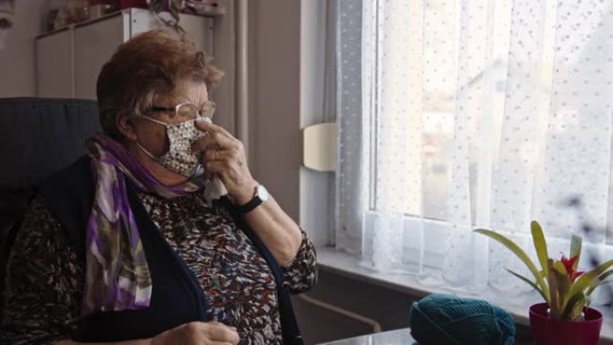 悲伤的老妇人在家庭检疫中哭泣和擦拭眼泪