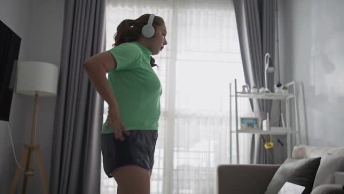 年轻超重女子在家在线锻炼