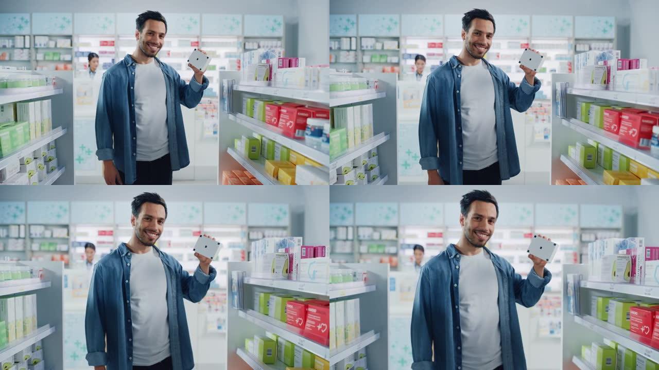 药房药店: 英俊的拉丁男子拿着带有跟踪标记的模拟模板药品包装的肖像，看着相机，开心地微笑。客户推荐最