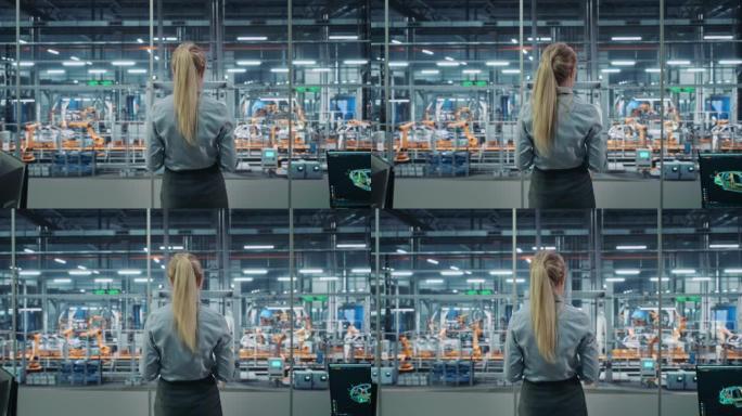 汽车厂办公室: 成功的女总工程师俯瞰工厂生产输送机。自动化机械臂装配线制造先进高科技电动汽车。后视图