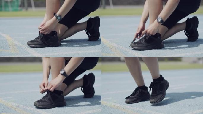 4k视频片段，一名无法识别的女运动员在赛道上系鞋带