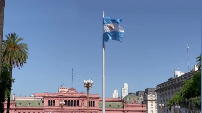阿根廷国旗在梅奥广场 (英语: May Square)，背景是布宜诺斯艾利斯中心的Casa Rosa