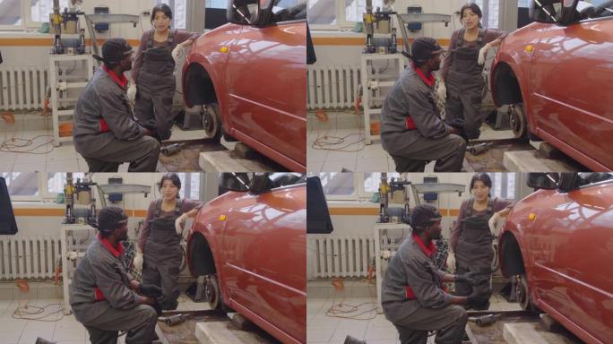 女机械师在汽车修理厂与男同事交谈