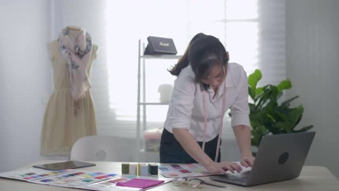 设计师使用笔记本电脑绘制衣服素描