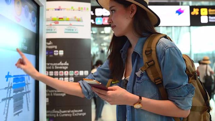 穿着旅游服的亚洲美女，检查有关航班时刻表的登机信息。出国旅行可以用于代表独自旅行的概念工作中。