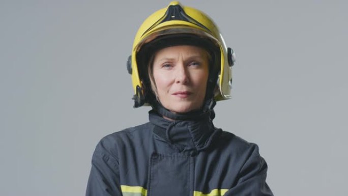 工作室肖像严肃的成熟女消防员戴着头盔，背景素色