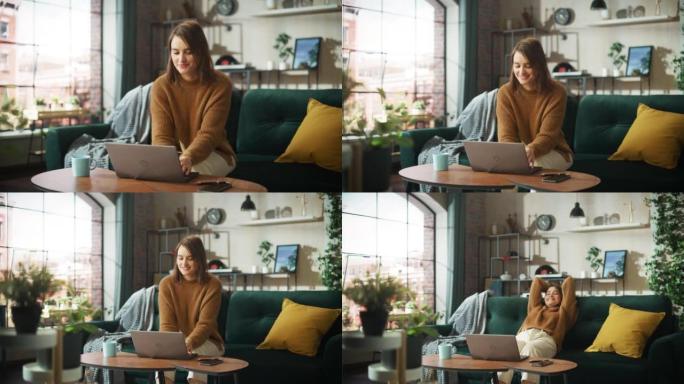 微笑的年轻女子在家在阳光明媚的舒适公寓里用笔记本电脑工作，放松身心，靠在沙发上。成功创意女企业家完成