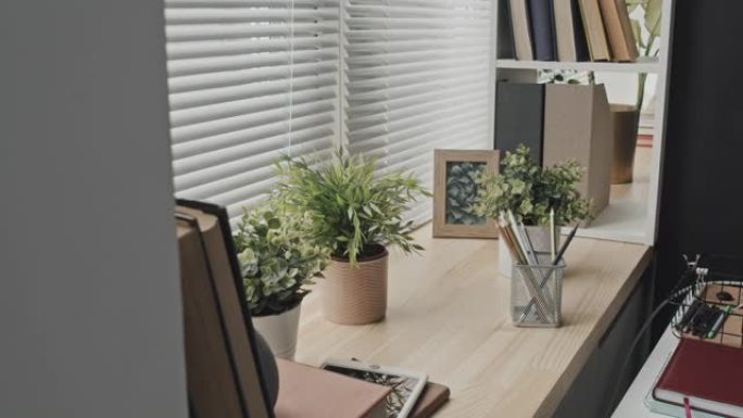 木制窗台上的办公用品和盆栽植物