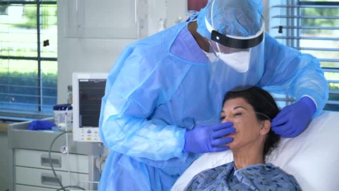 PPE男护士调整女性患者的氧气管