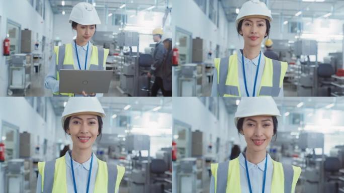 电子制造厂一位戴着白色安全帽的快乐微笑的亚洲女工程师的肖像，站在笔记本电脑上。成功的重工业专家摆姿势