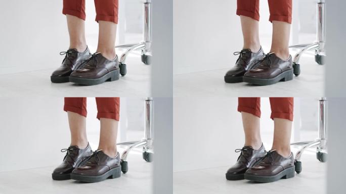 4k视频片段，一个无法辨认的商人的腿在工作中的办公室里不安地移动