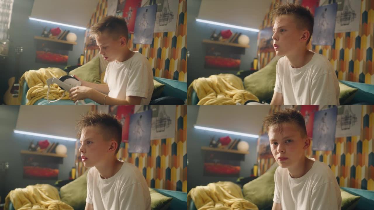 十几岁的男孩在玩游戏后脱下虚拟现实耳机坐在沙发上
