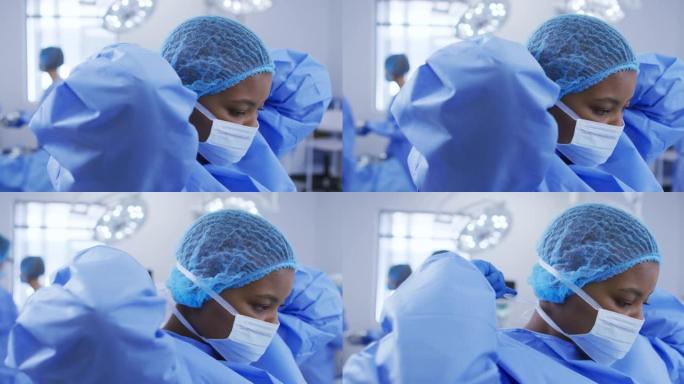 非裔美国女外科医生戴着手术帽，在手术室戴上口罩