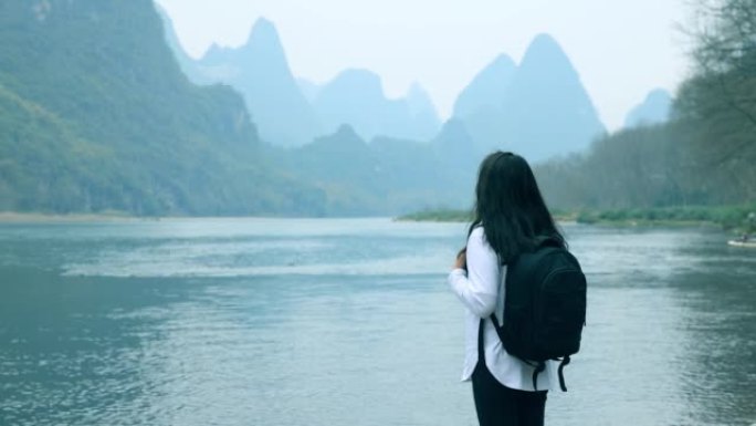 在中国桂林的漓江边散步的女游客