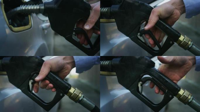 年轻人的特写镜头正在将燃油泵放入加油站加油的汽车中。概念: 经济、能源、交通、汽油工业、绿色燃料、环