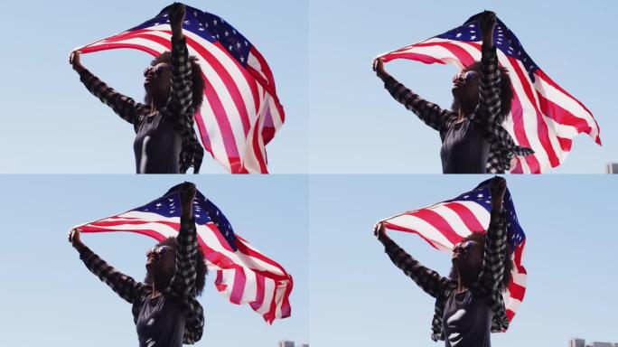 戴着墨镜的非洲裔美国妇女高举美国国旗