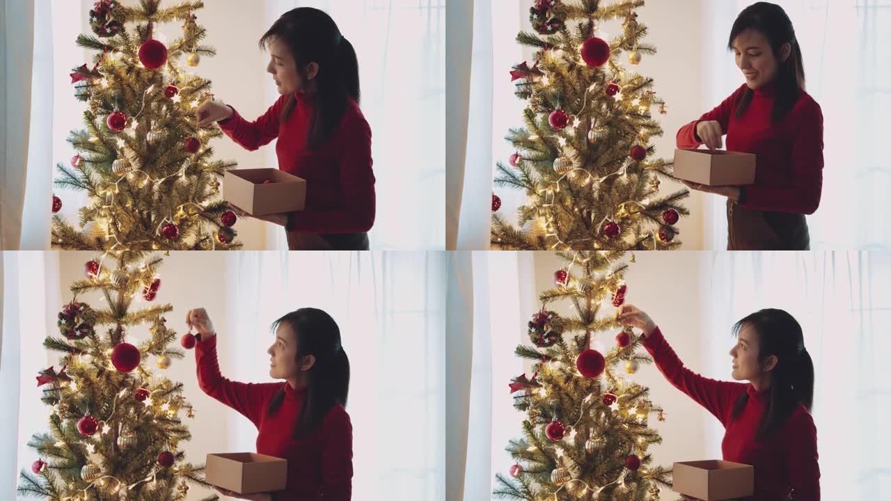 年轻女子在家里装饰圣诞树前。