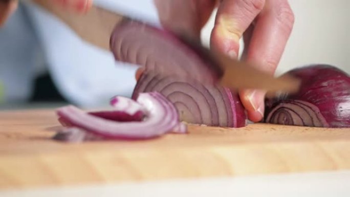 4k视频片段，一名男子切碎红洋葱准备用餐