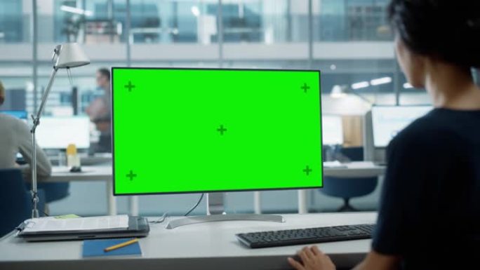 用色度键绿屏模拟显示在台式计算机上工作的女商人的肩膀特写镜头。数字项目经理使用键盘和鼠标键入数据。