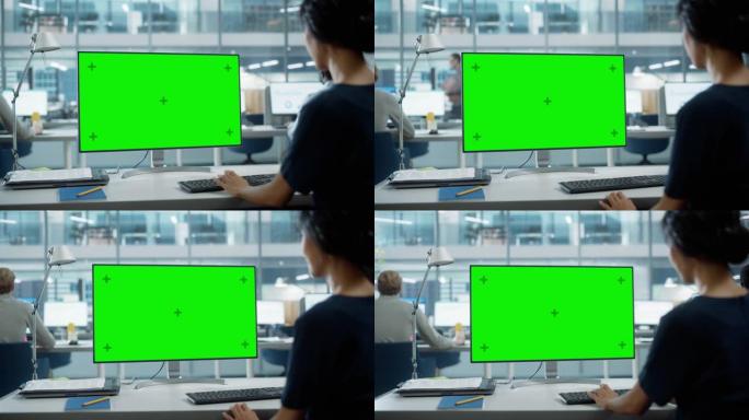 用色度键绿屏模拟显示在台式计算机上工作的女商人的肩膀特写镜头。数字项目经理使用键盘和鼠标键入数据。