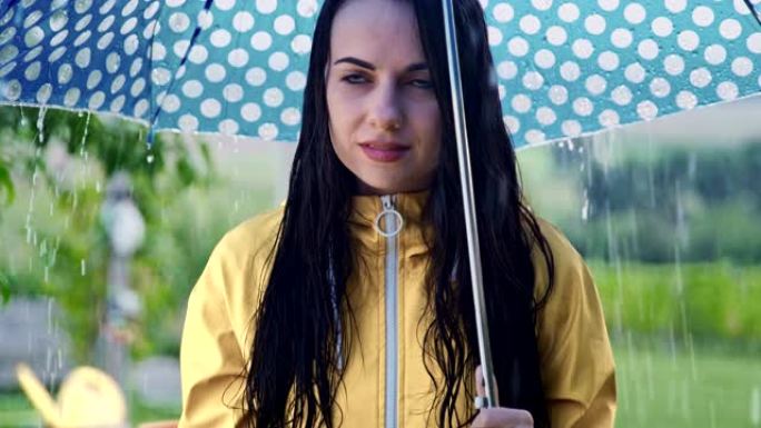 一名年轻女子在雨中使用智能手机的SLO MO肖像