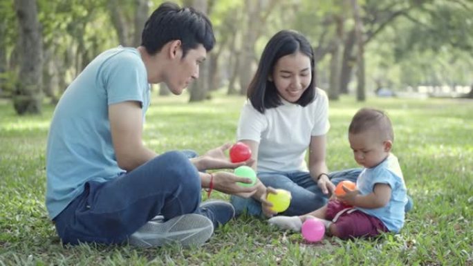 SLO MO亚洲家庭在公园玩彩球