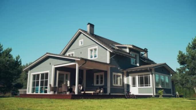 建立镜头: 美丽的蓝天弧线镜头，带有传统建筑的大型现代乡村住宅。私人住宅站在风景秀丽的绿色草坪上。