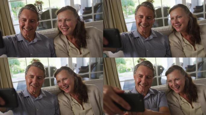 快乐的白人高级夫妇坐在客厅微笑着自拍
