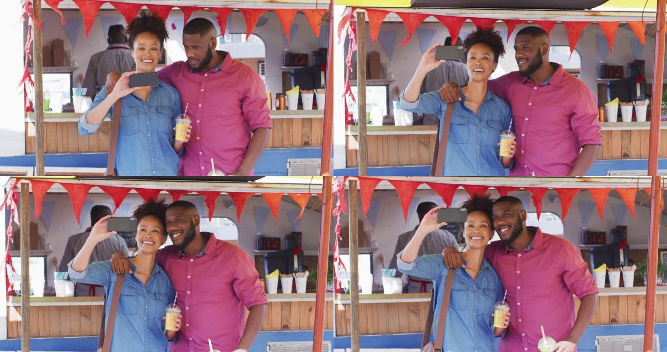 非洲裔美国夫妇拿着冰沙微笑着在餐车上自拍