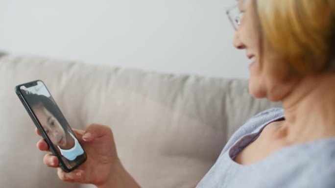 祖父母在家中通过智能手机与孙子交谈，与家人联系