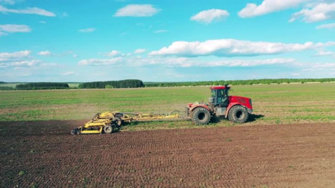 耕犁机骑在农场上，用犁沟工作。