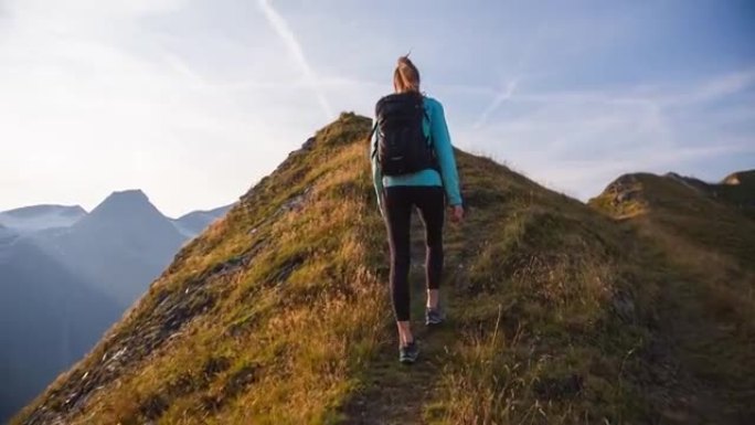 年轻的健身女子保持健康，在山上高高的空气，在山脊上徒步旅行