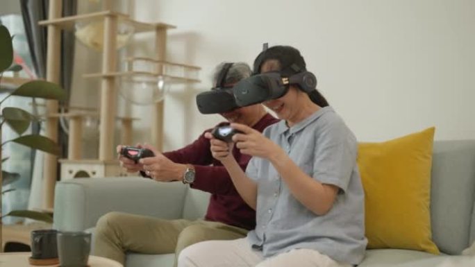 亚洲夫妇老人很乐意玩戴虚拟眼镜的电子游戏。