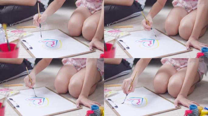 特写亚洲小女孩在家时在客厅手工绘画和绘画她的艺术和工艺。她喜欢用水彩和画笔在白纸上创作艺术作品，并从