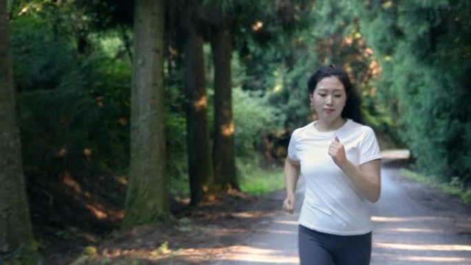 在森林小径上奔跑的妇女